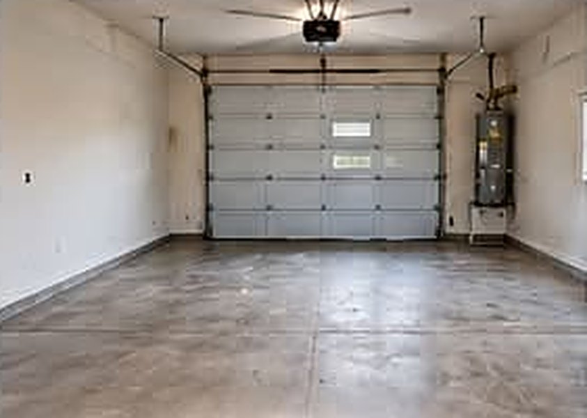 A plain, stained concrete garage floor before coating